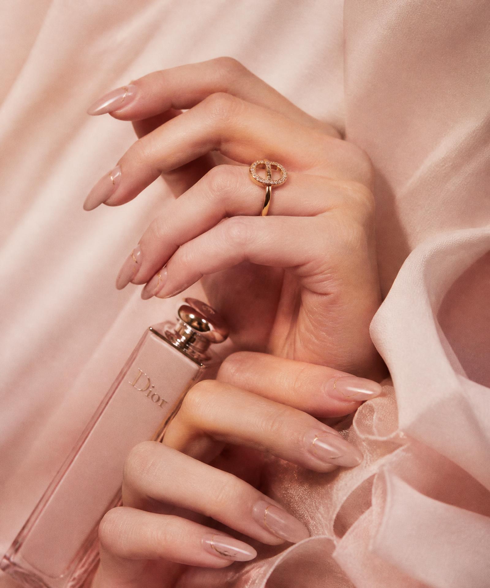 Elegant nude almond nails with fine gold detailing on blush silk